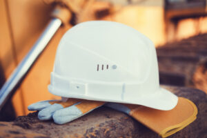 Photo of hard hat resting on top of work gloves