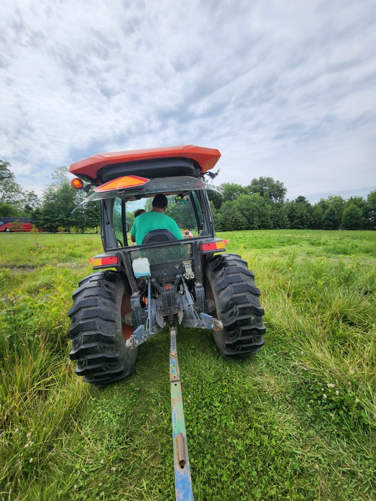 Image from behind of a farmer driving a tractor through a field